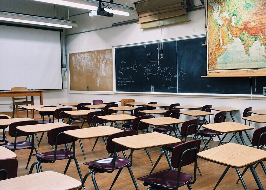 Empty Classroom with Desks, Blackboard, and World Map