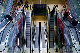 Symmetrical View of People Riding Escalators in Modern Mall