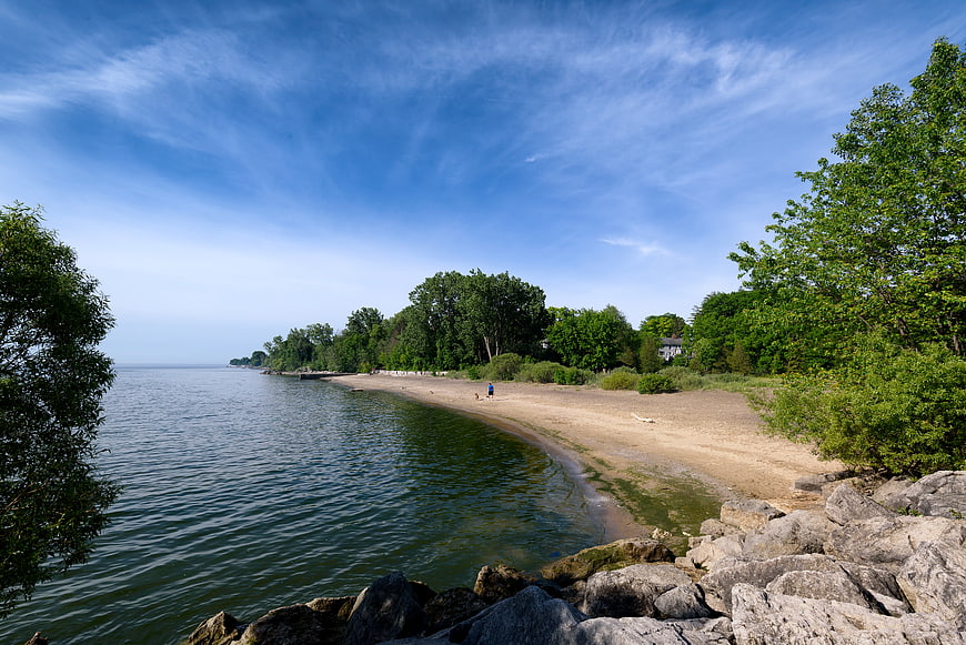 Serene Lake Shoreline with Sandy Beach and Blue Sky