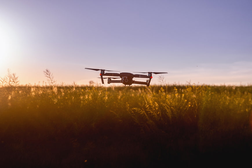 Drone Flying Over Golden Field at Sunset