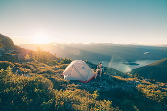 Man Camping on Mountain Ridge at Sunrise