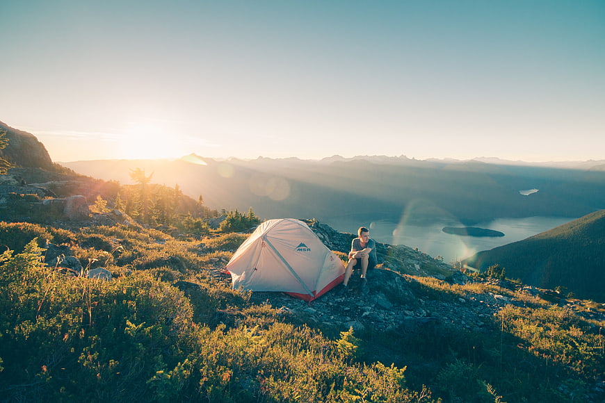 Man Camping on Mountain Ridge at Sunrise