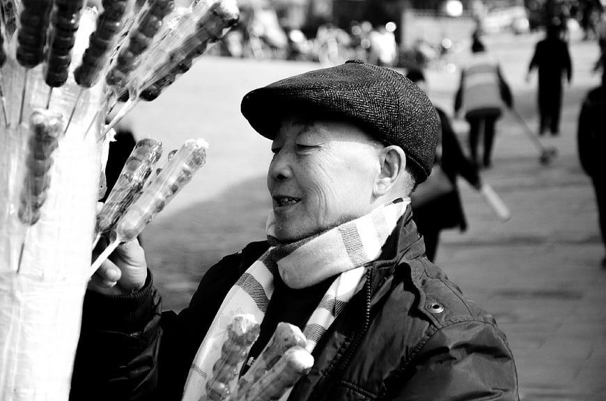 Senior man selling candied fruit on the street