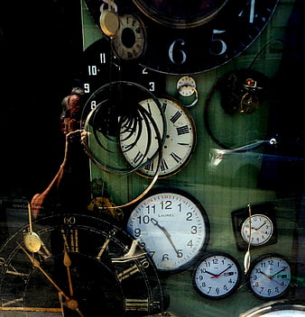 Clock repairman working on vintage timepieces in workshop