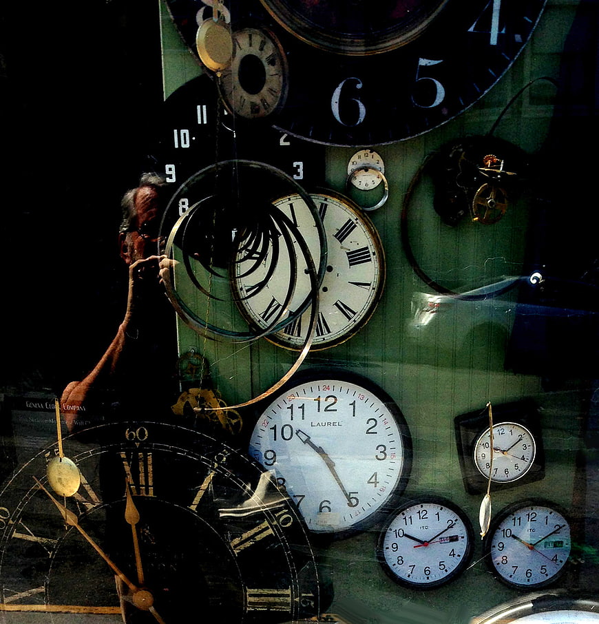 Clock repairman working on vintage timepieces in workshop