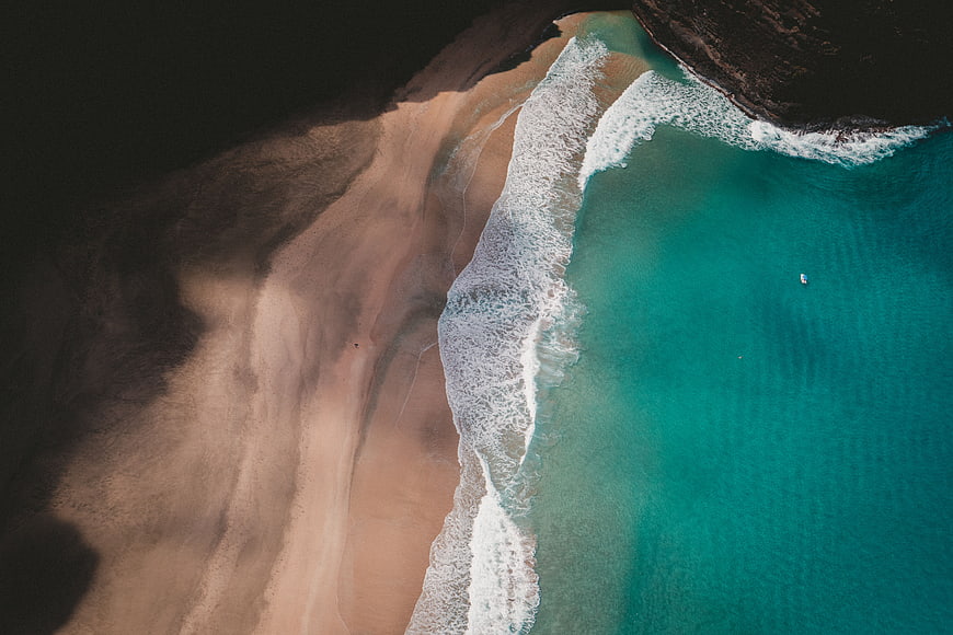 Aerial View of Turquoise Ocean Waves Crashing on Sandy Beach