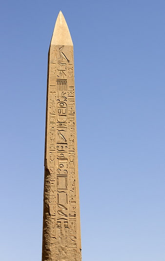 Ancient Egyptian Obelisk with Hieroglyphs Against Blue Sky