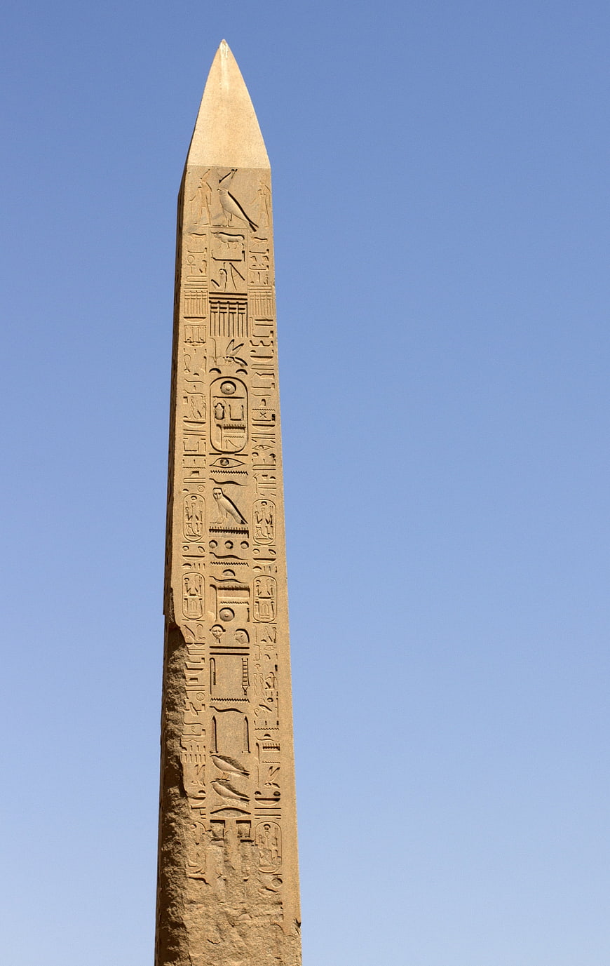 Ancient Egyptian Obelisk with Hieroglyphs Against Blue Sky