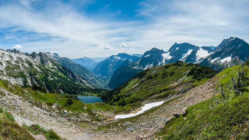 Panoramic Alpine Landscape with Snow-Capped Peaks and Mountain Lake