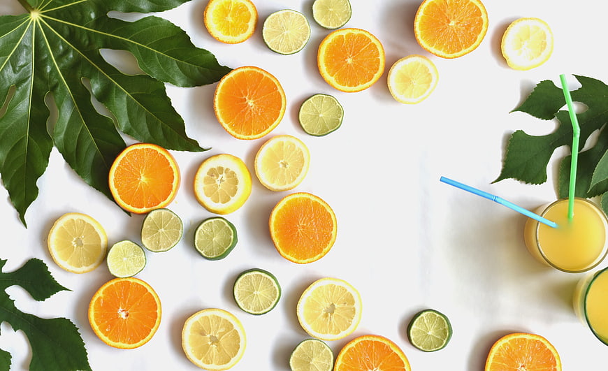 Fresh citrus fruit slices and juice flat lay on white marble