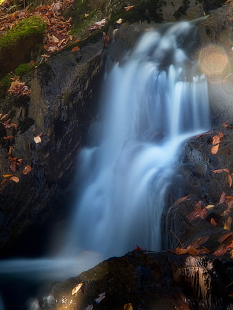 Long Exposure Waterfall in Autumn Forest with Mossy Rocks