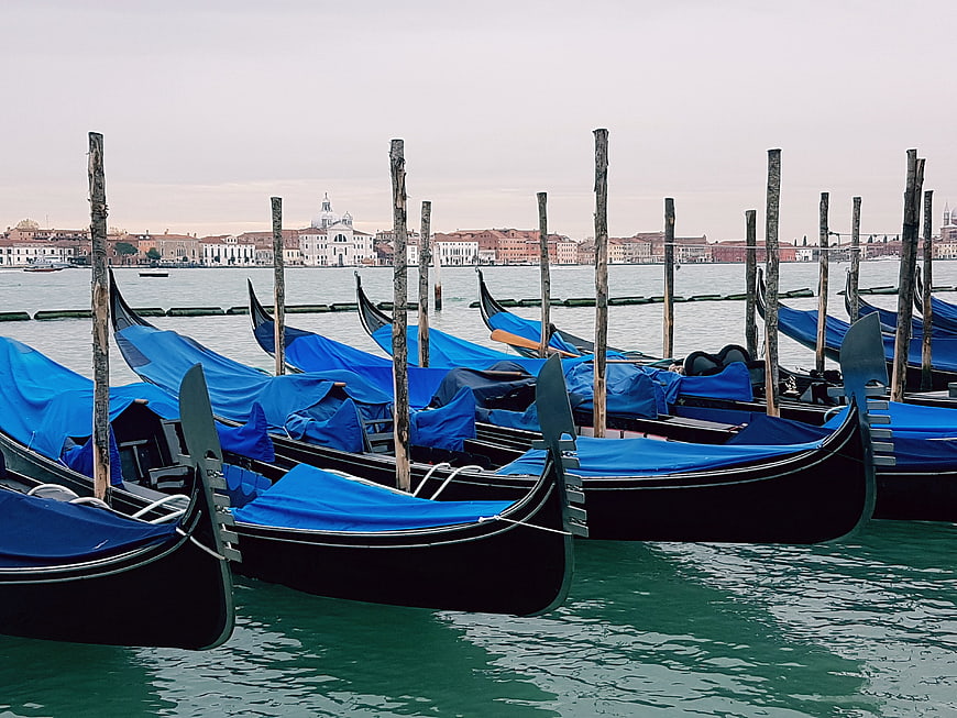 Blue Covered Gondolas Moored in Venice Canal