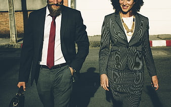 Businessman and businesswoman walking together in professional suits