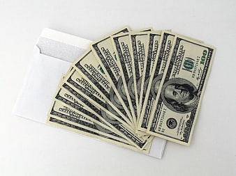 Stack of hundred dollar bills on white envelope