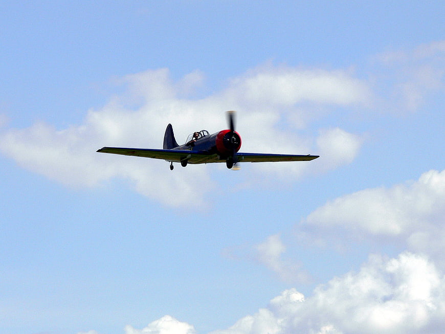 Vintage Yak Propeller Airplane Flying in Blue Sky