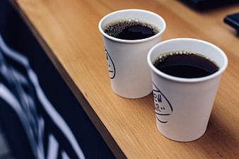 Two Paper Cups of Black Coffee on Wooden Table