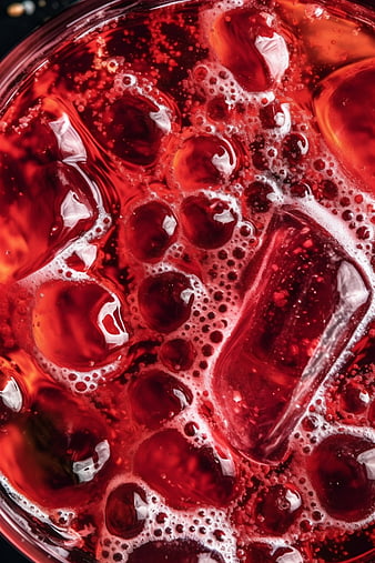 Macro shot of red iced beverage with bubbles