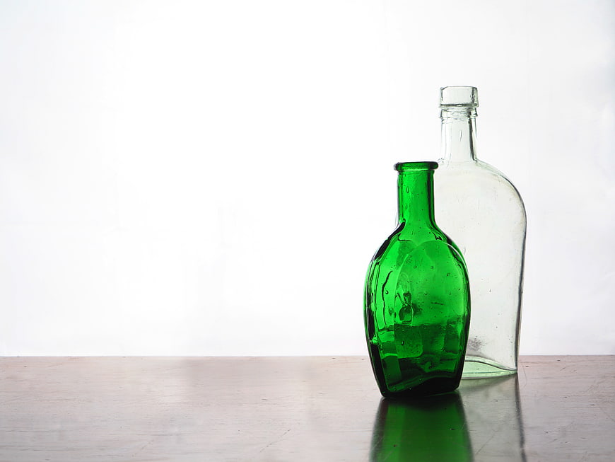 Vintage Green and Clear Glass Bottles on Wooden Table