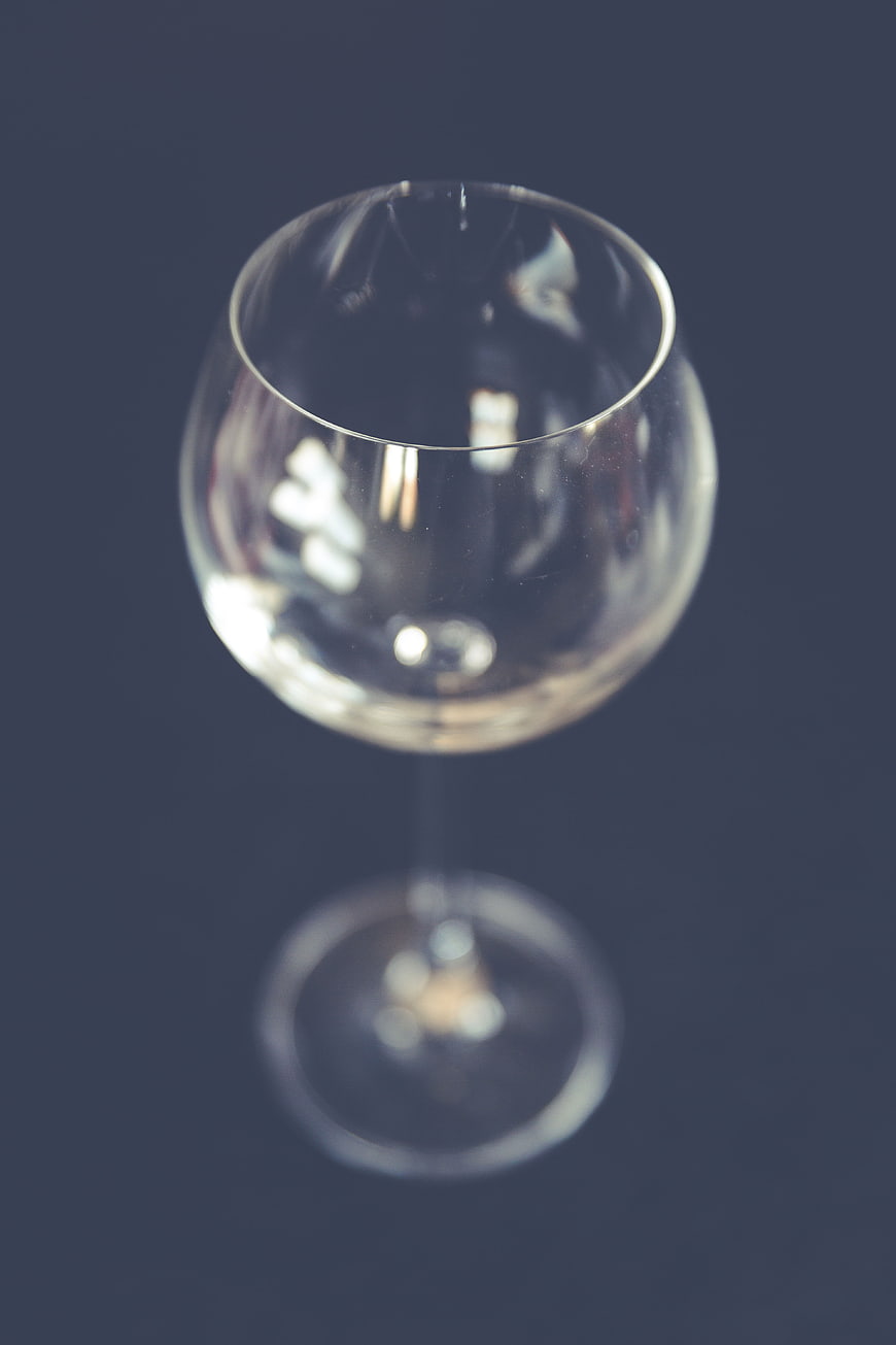 Empty wine glass on dark background with bokeh
