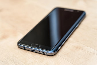 Black Samsung Galaxy S7 Edge on Wooden Surface