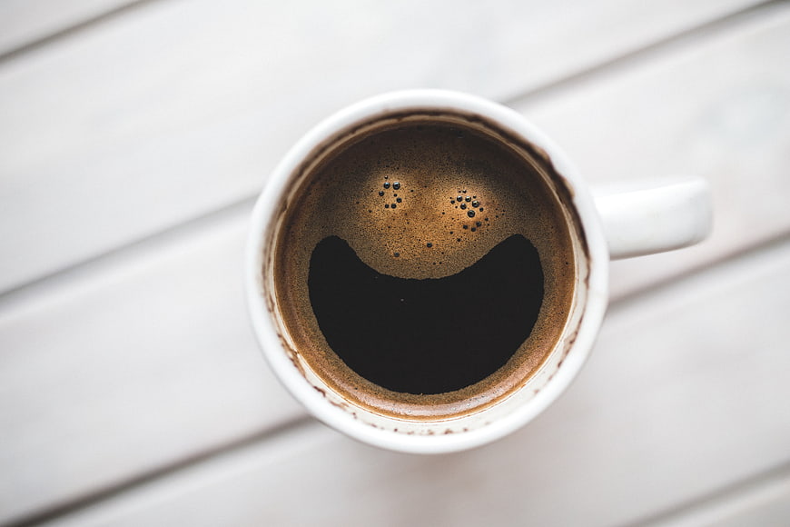 Top View of Black Coffee in White Mug on Wooden Table