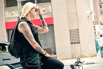 Blonde Woman with Tattoos and Sunglasses on Bicycle