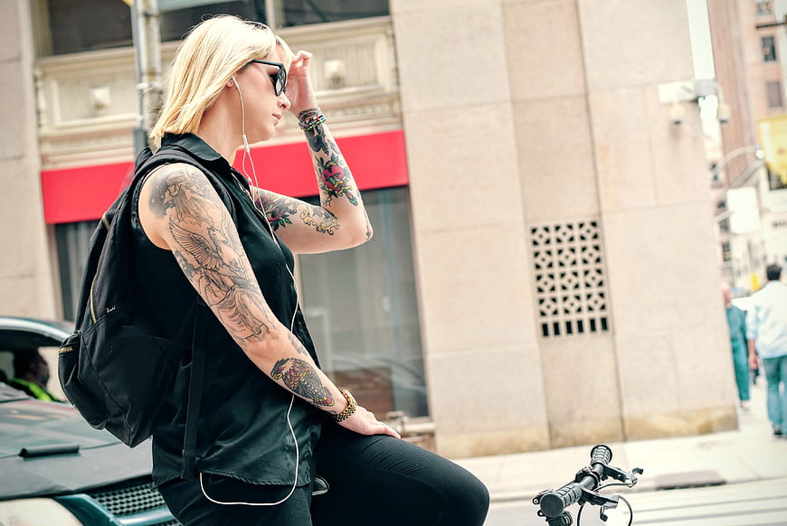 Blonde Woman with Tattoos and Sunglasses on Bicycle