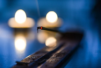 Burning incense stick with candle bokeh background