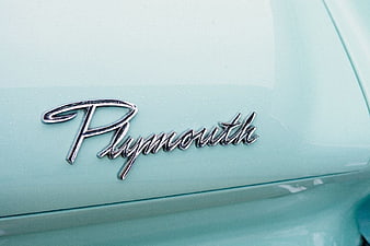Close-up of Vintage Plymouth Car Emblem on Mint Green Paint