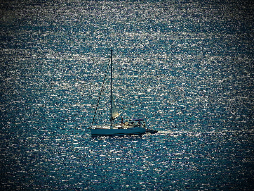 Aerial view of sailboat on shimmering blue sea