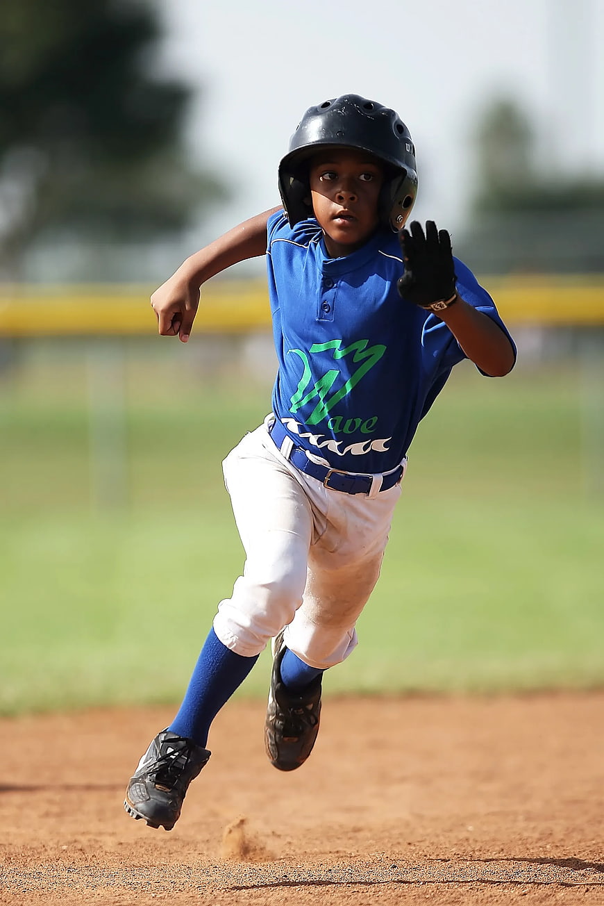 Young Baseball Player Running on Dirt Field