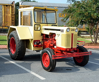 Vintage yellow and red Case M570 tractor parked outdoors