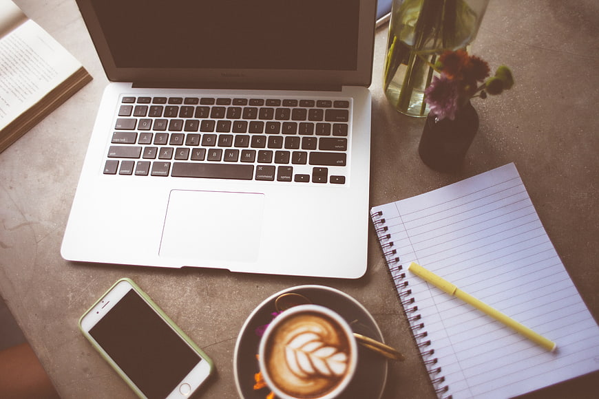 Flat lay workspace with laptop, coffee, and notebook