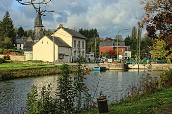 Scenic European Canal Lock with Church and Autumn Foliage