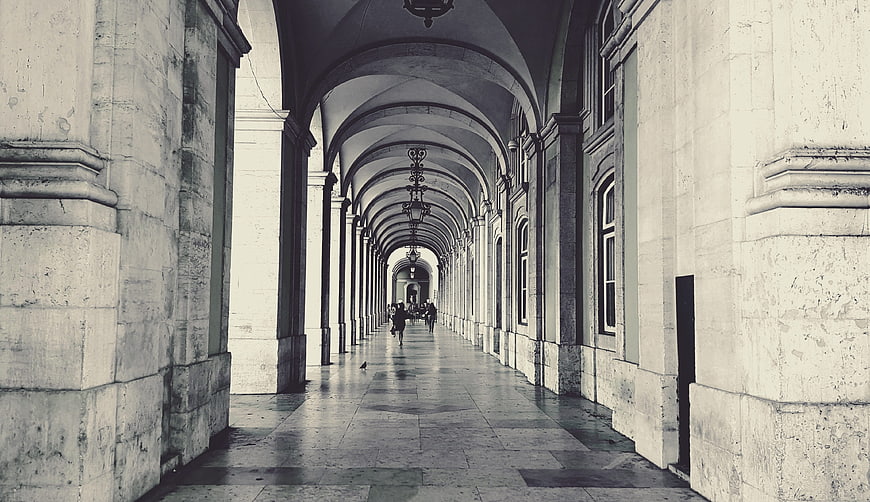 Perspective of historic stone arcade corridor in Lisbon
