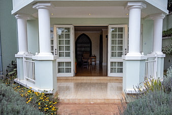 Elegant House Entrance with White Columns and Garden