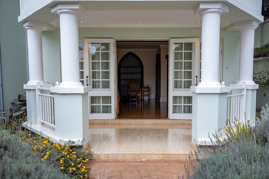 Elegant House Entrance with White Columns and Garden