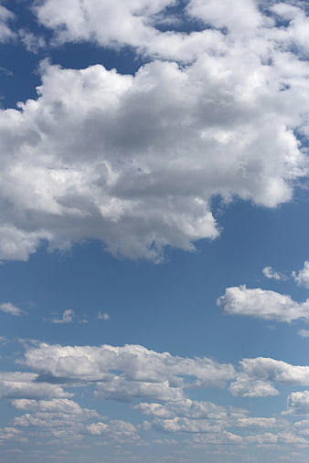 White Cumulus Clouds Against Blue Sky Background