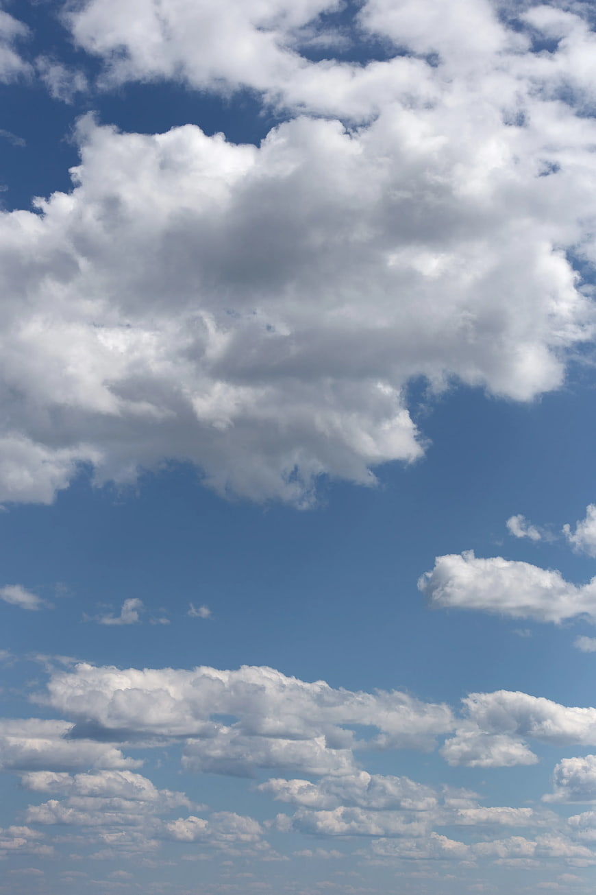 White Cumulus Clouds Against Blue Sky Background