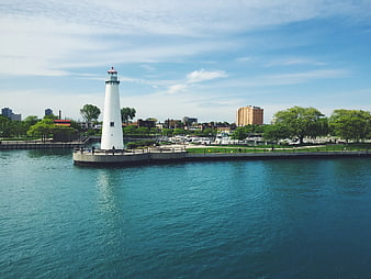 White Lighthouse on Pier with City Skyline Background