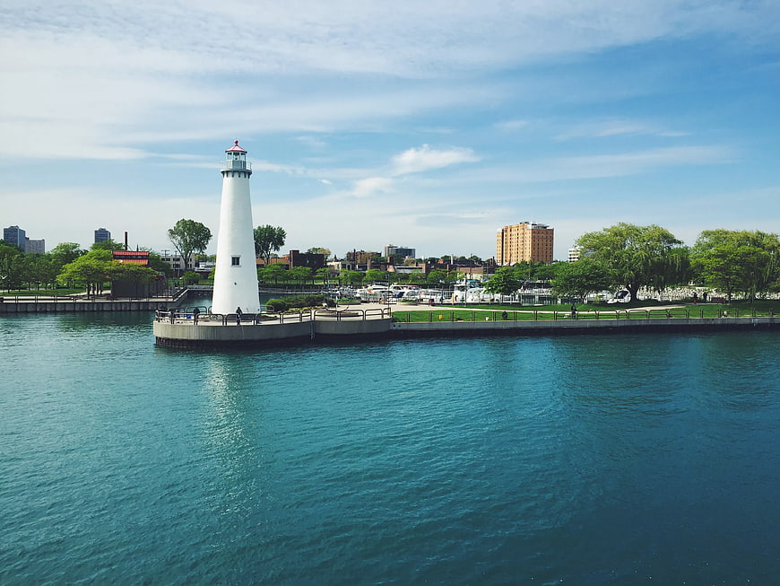 White Lighthouse on Pier with City Skyline Background