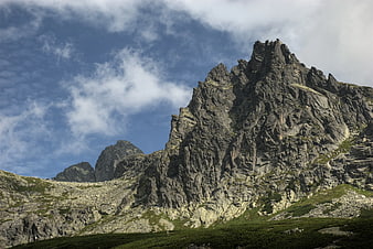 Dramatic Rocky Mountain Peak with Blue Sky and Clouds
