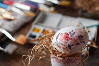 Hand-painted Easter egg with floral design in nest