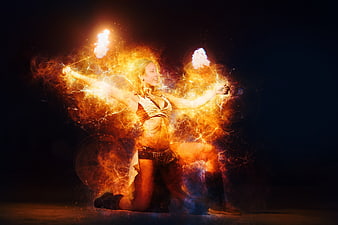Female Fire Performer Kneeling With Burning Torches In Dark Studio