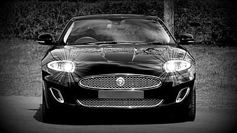 Front view of black luxury sports car with headlights on