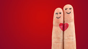 Finger puppets with faces and heart on red background