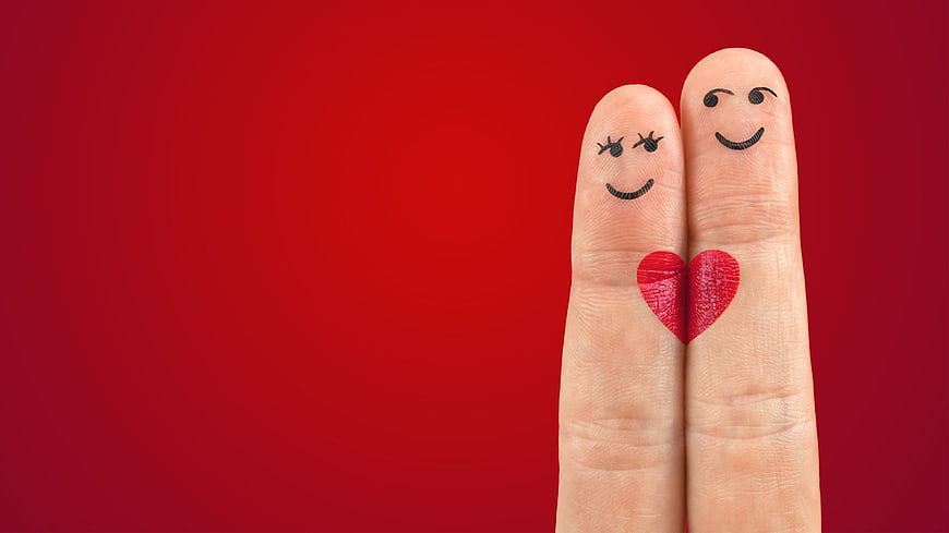 Finger puppets with faces and heart on red background
