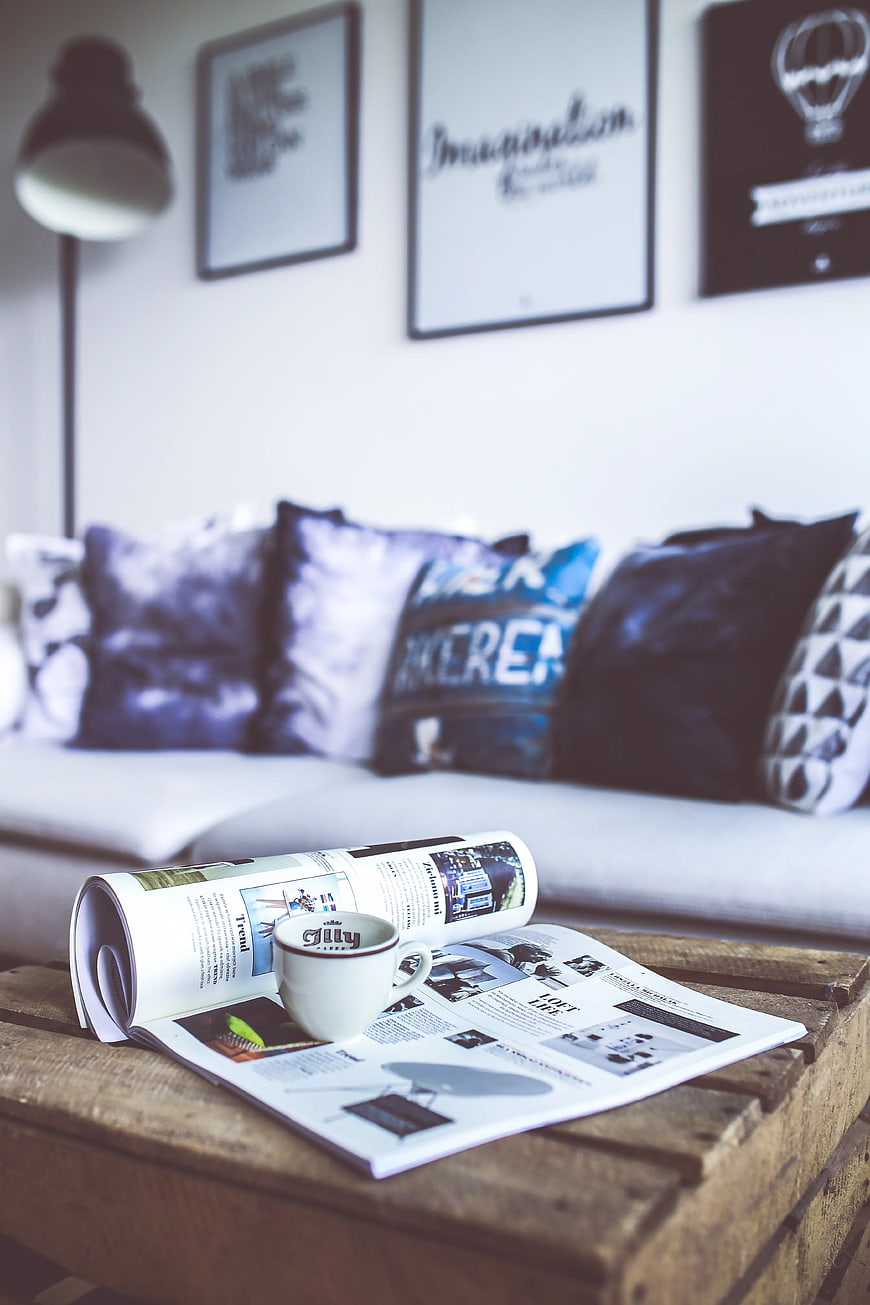 Coffee cup and magazine on wooden table in living room
