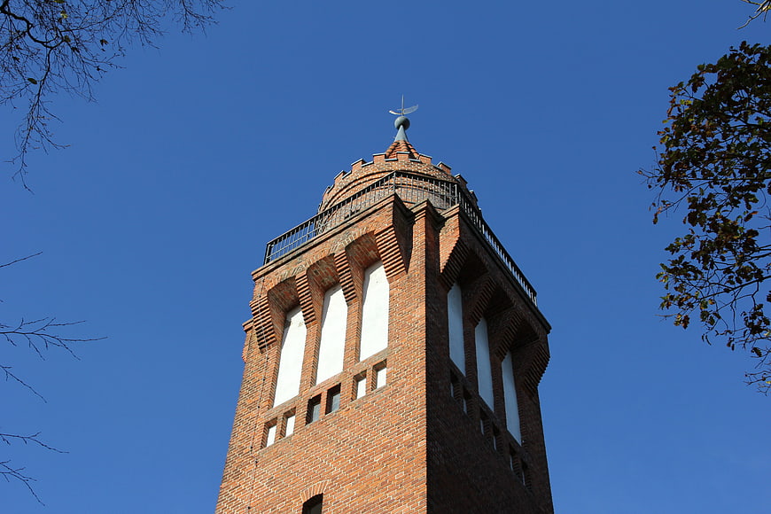 Low angle view of red brick observation tower against blue sky