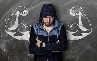 Disappointed man in hoodie with chalk muscle drawings